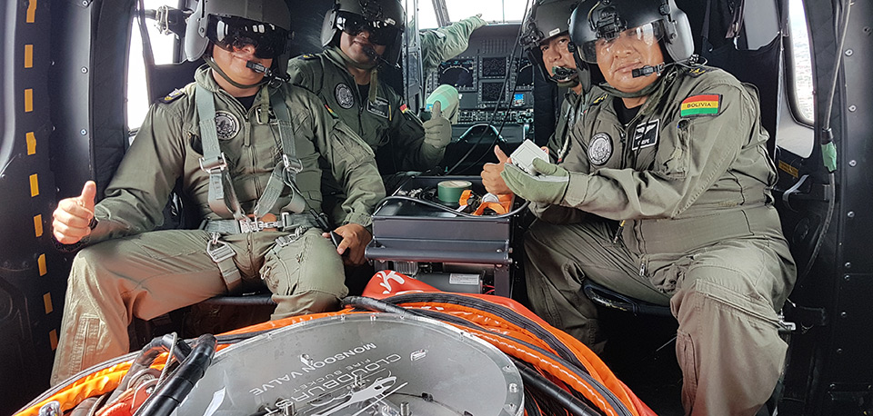 Bolivian aerial firefighting crew inside a helicopter with a monsoon bucket valve system