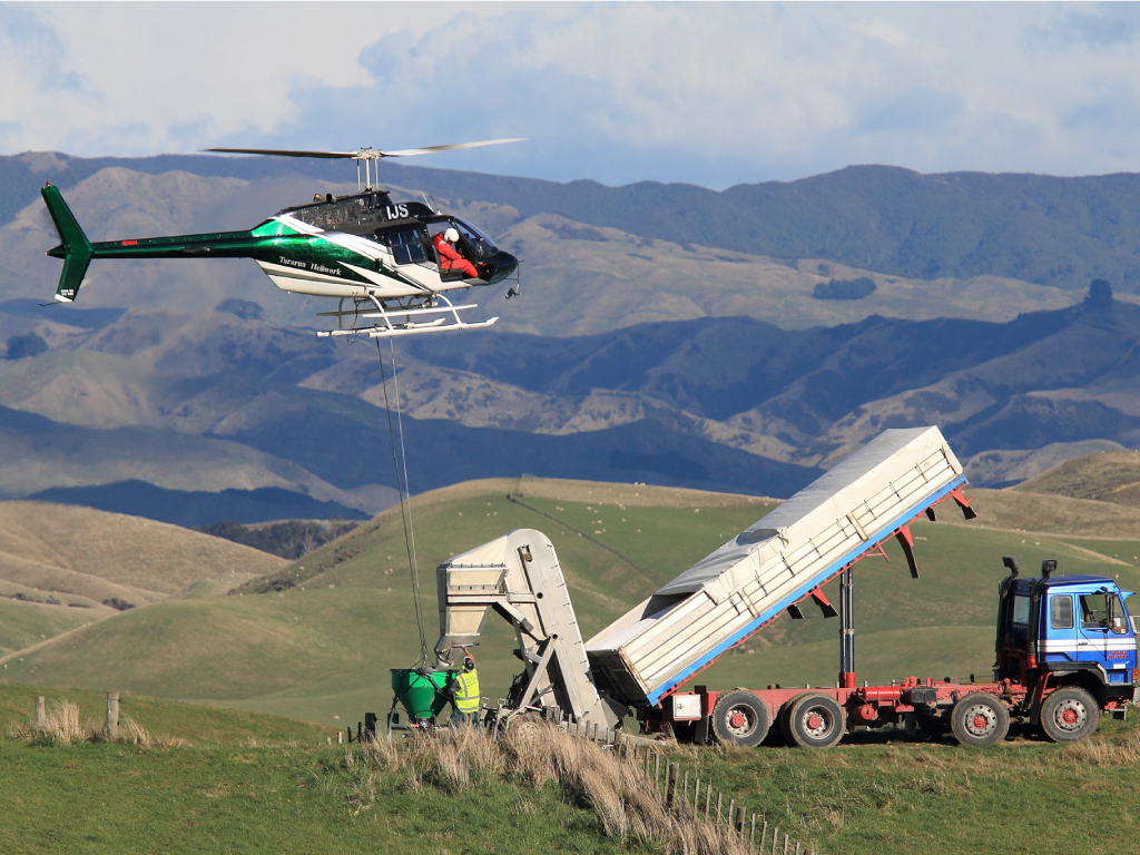 Hovering to load the Ground-Effect spreader bucket from a mobile truck conveyor system in a hilly landscape